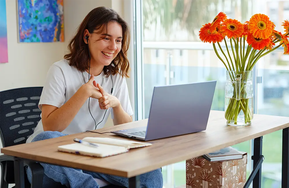 Eine junge Frau lernt von Zuhause aus am Computer.